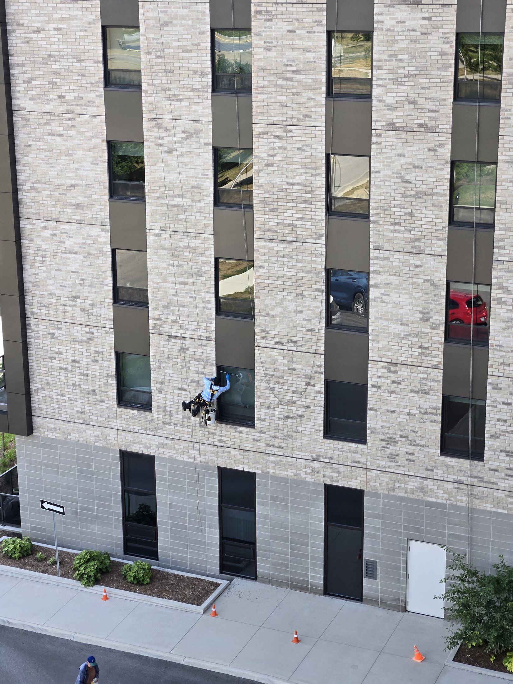 Rope-access window cleaner working on a multi-storey retirement residence