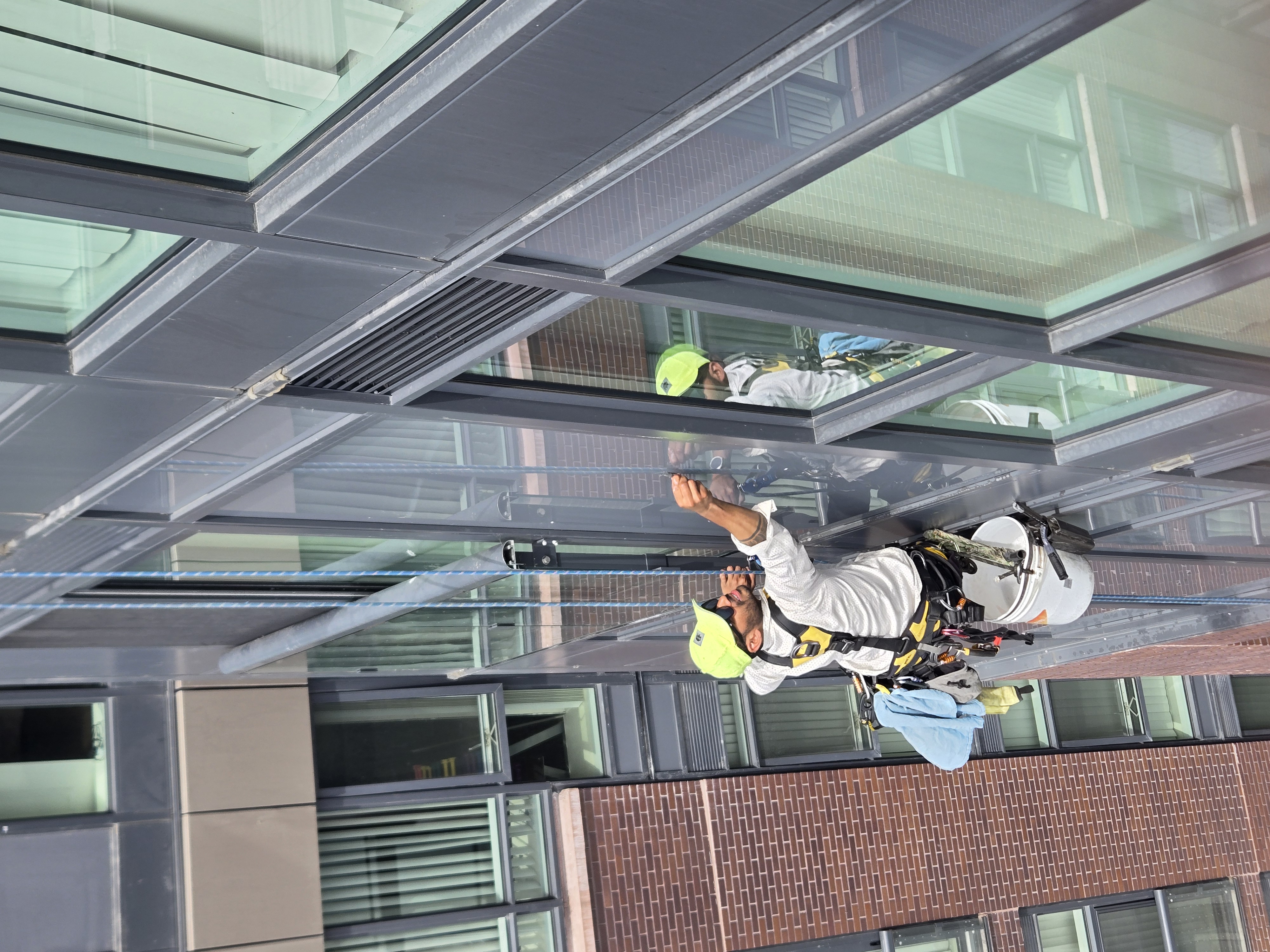 Rope-access window cleaner working on a multi-storey commercial building